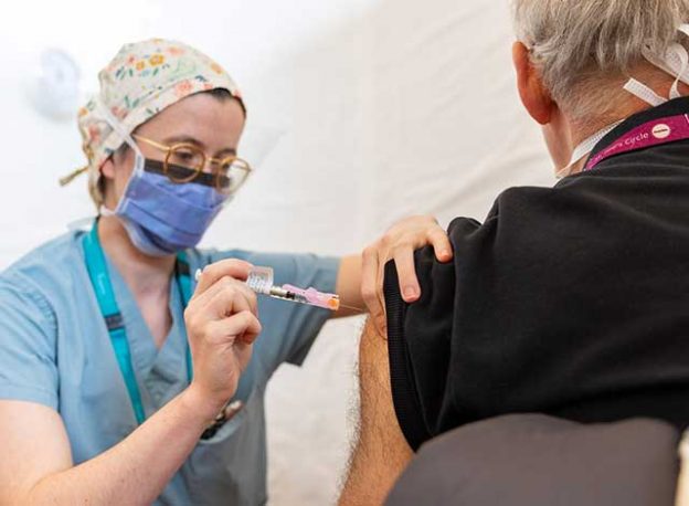 Nurse/Doctor administering vaccine to an elderly gentleman.