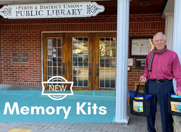 Ray Hook hold memory kits in front of the Perth Public Library