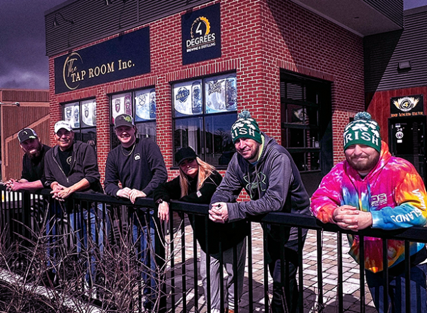 Front of The Tap Room Inc. with new owners standing in front.