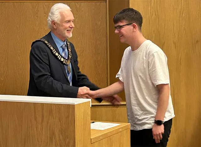 Mayor Shawn Pankow shaking the hand of student councillor Ryker Smith.
